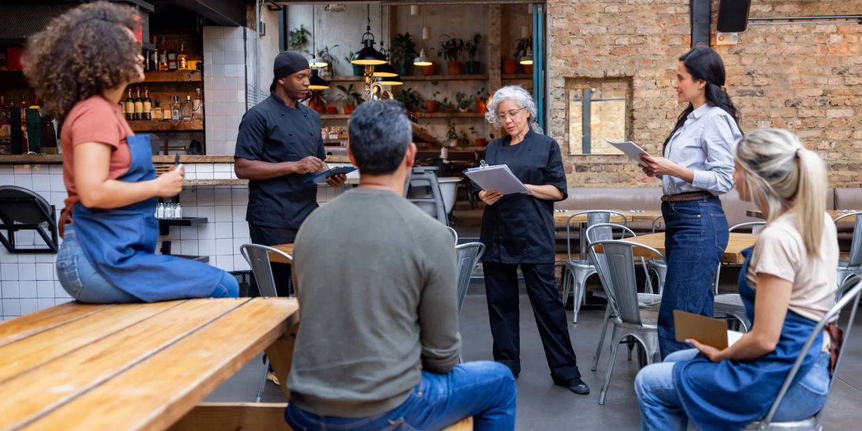 Restaurant staff having a meeting indoors.