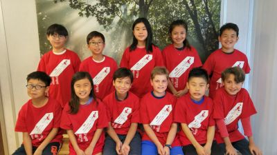 Group of children in red shirts posing for a photo.