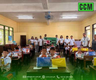 Children and teachers in a classroom with educational materials and CCM branding.