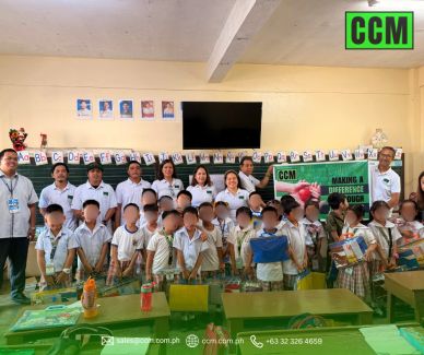 Group photo of teachers and young students in a classroom holding a CCM banner.