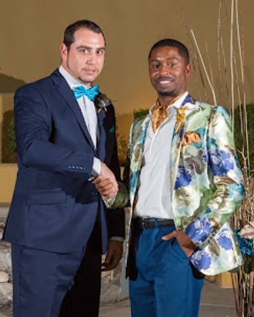 Men in nice suits shaking hands posing for the picture