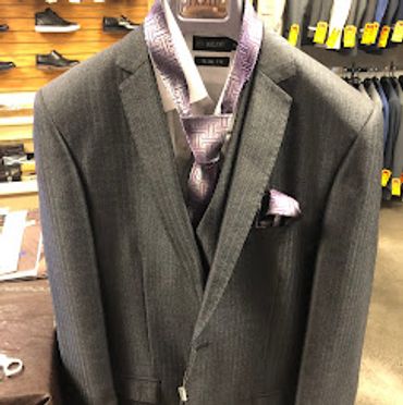Slim fit shadow stripe medium gray suit hanging with a purple and grey tie/hanky set