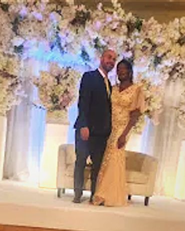 Man standing in black suit with his woman standing date night