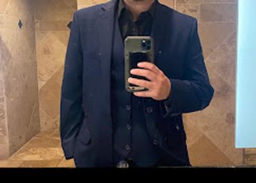 guy taking a selfie in the mirror in his new black suit and black shirt