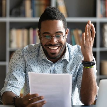 Smart African student guy holding papers printed tasks do test prepares for examination enjoy study 