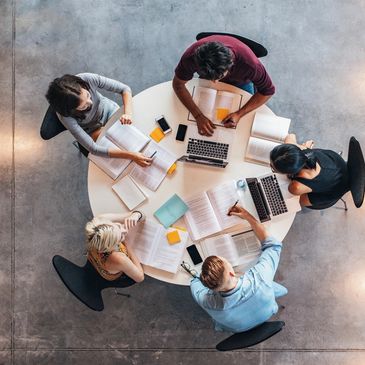 Top view of group of students sitting together at table. University students do group study.
