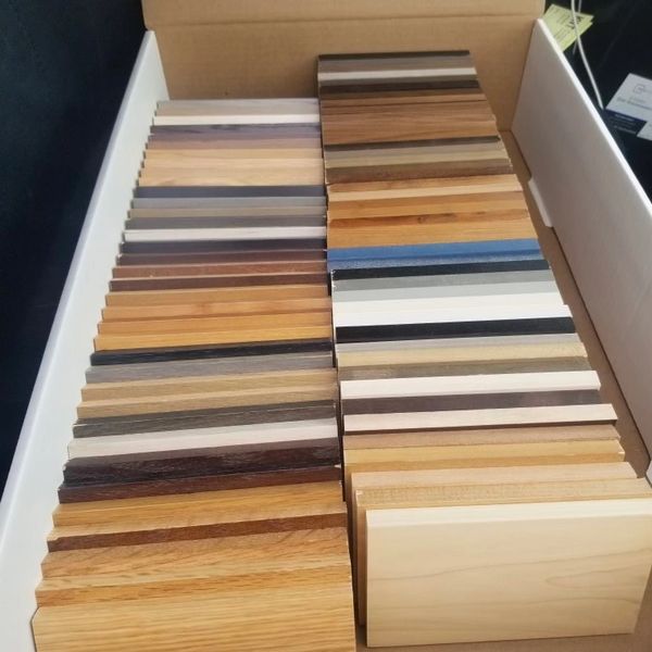 Box with various wood laminate and veneer samples in different colors and finishes.