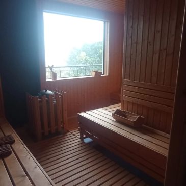 Interior de sauna con bancos y ventanas de madera.