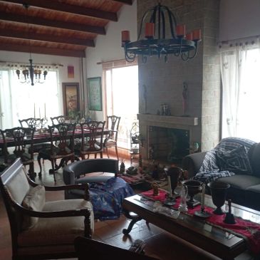 Sala de estar y comedor con chimenea y decoración clásica.