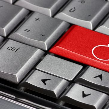 Close-up of a keyboard with a red key featuring a white apple icon.