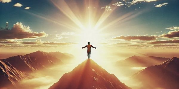 A content person standing on a mountain peak at sunrise, arms outstretched, glowing in golden light.