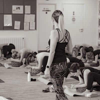 Yoga class with instructor observing students.