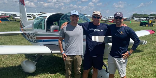 Appraiser with his dad and brother and airplane at Oshkosh