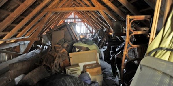 An attic full of junk, furniture, mattresses, garbage, trash that needs to be removed by Junkosaur.