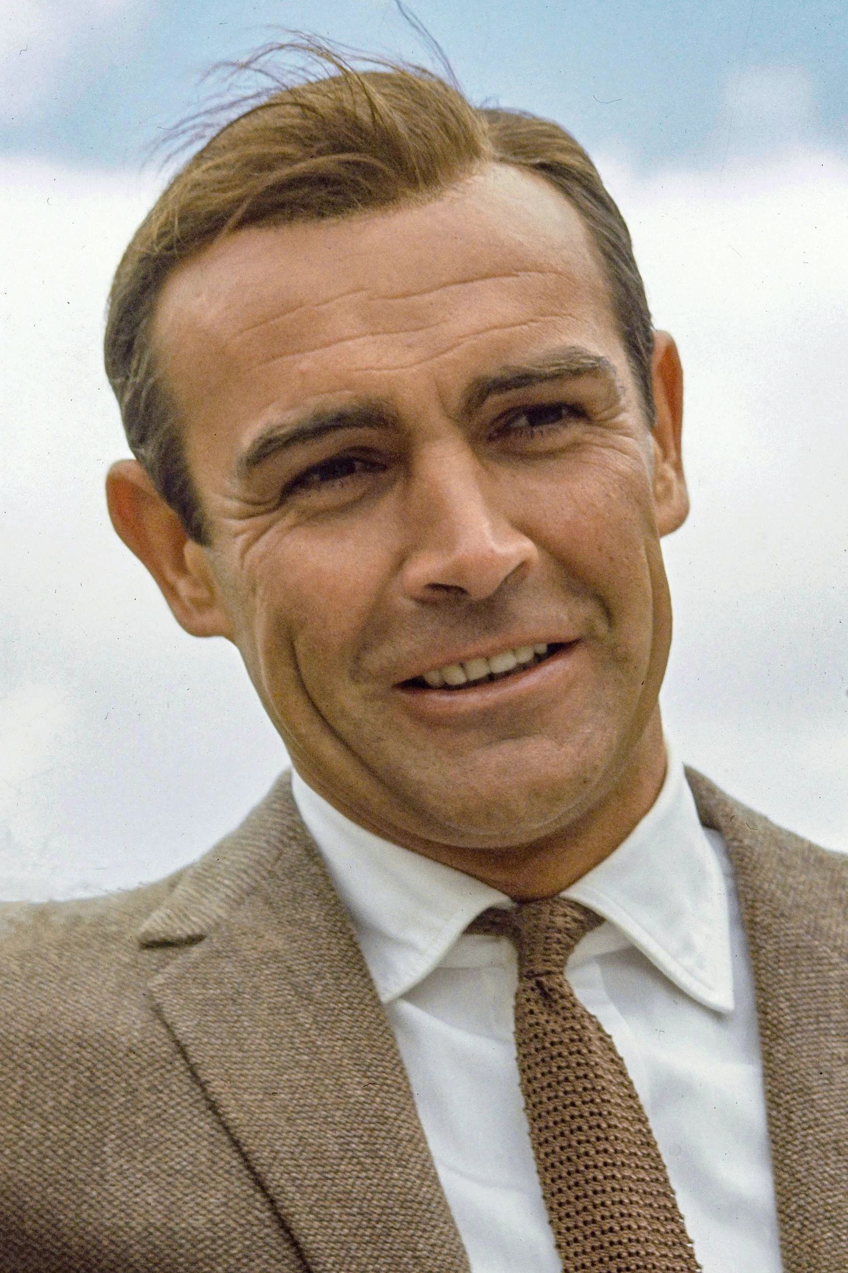 Smiling man in a suit and tie.