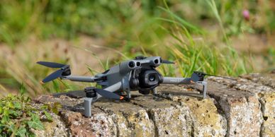 A drone resting on a stone surface in a grassy area.