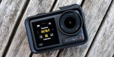 DJI Action 4 camera showing 4K recording settings on a wooden surface.