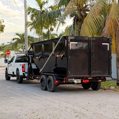 Heavy-duty commercial dumpster trailer staged for active job site logistics in South Florida.