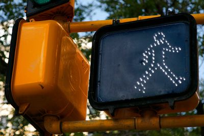 Illuminated pedestrian crossing signal showing a walking figure.