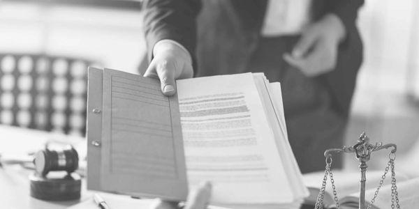 Person handing over legal documents in an office.