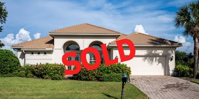A sold single-story house with a tiled roof and a two-car garage.