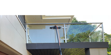 Glass balustrade being cleaned by First Choice Exterior Solutions

