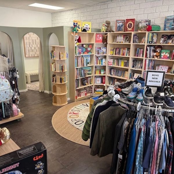 Cozy children's store with books, clothes, and shoes neatly displayed.