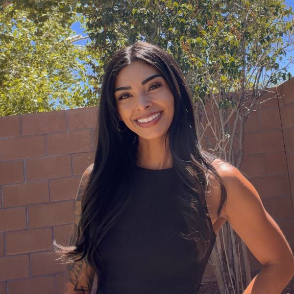 Smiling woman with long black hair in a sleeveless top.