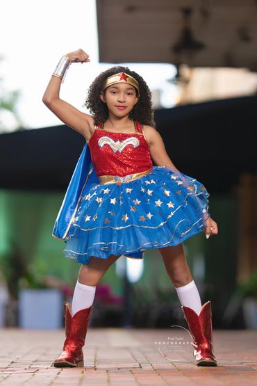 Young girl dressed as Wonder Woman striking a strong pose.