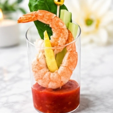 Shrimp cocktail appetizer in a small glass with sauce.