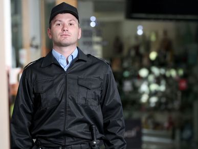 Security guard standing alert in uniform.