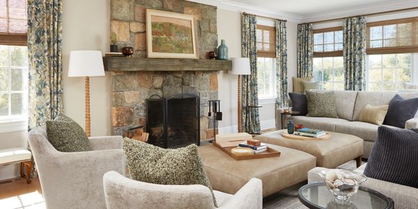 Cozy living room with stone fireplace and neutral furniture.