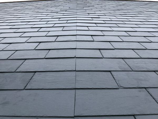 A symmetrical slate roof with neatly arranged tiles.