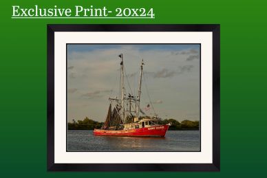 Framed photo of a red fishing boat on calm waters under a cloudy sky.