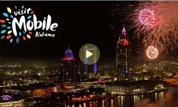Night view of Mobile, Alabama with fireworks and city lights.
