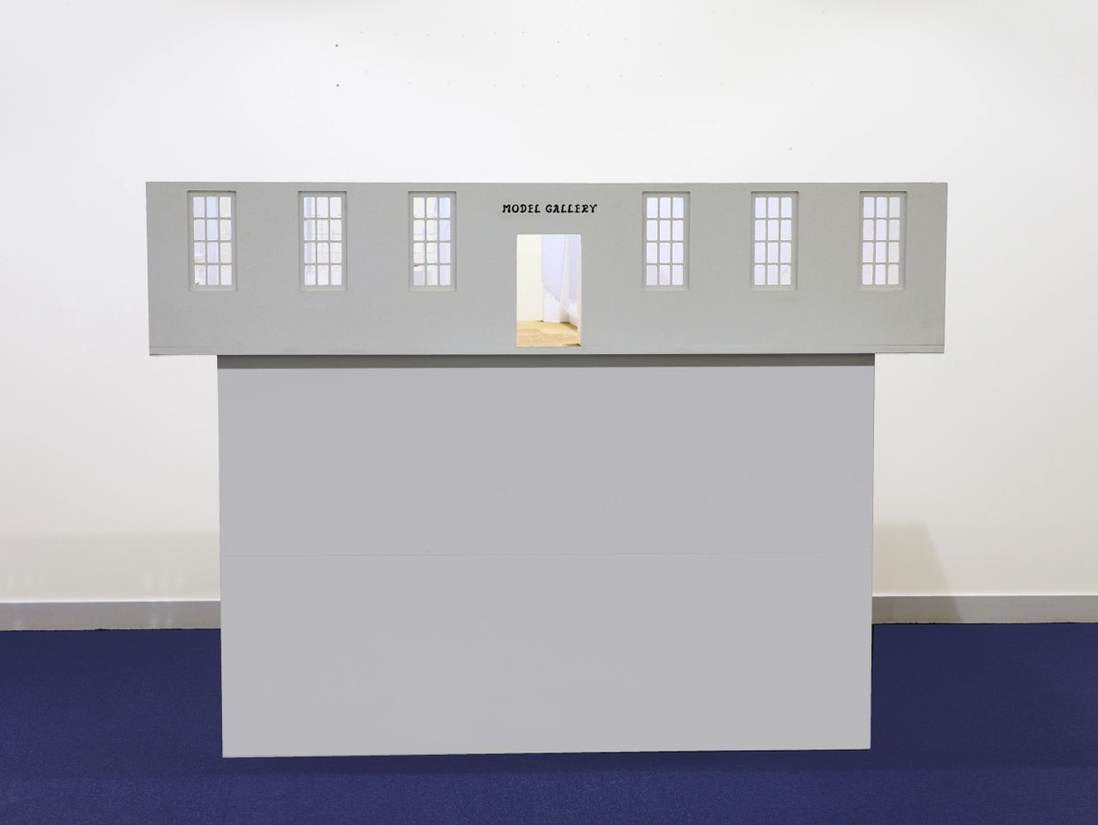 Minimalist model gallery structure with windows and an open doorway.