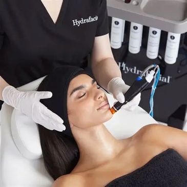 Woman receiving a hydrafacial treatment.