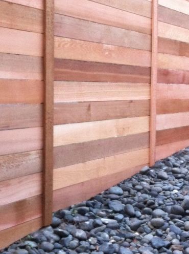 Cedar horizontal fence with top cap and vertical seam boards. 