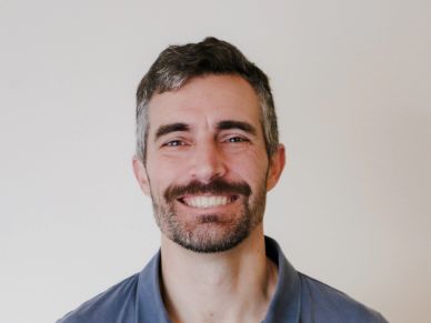 Smiling man with short dark hair and beard.