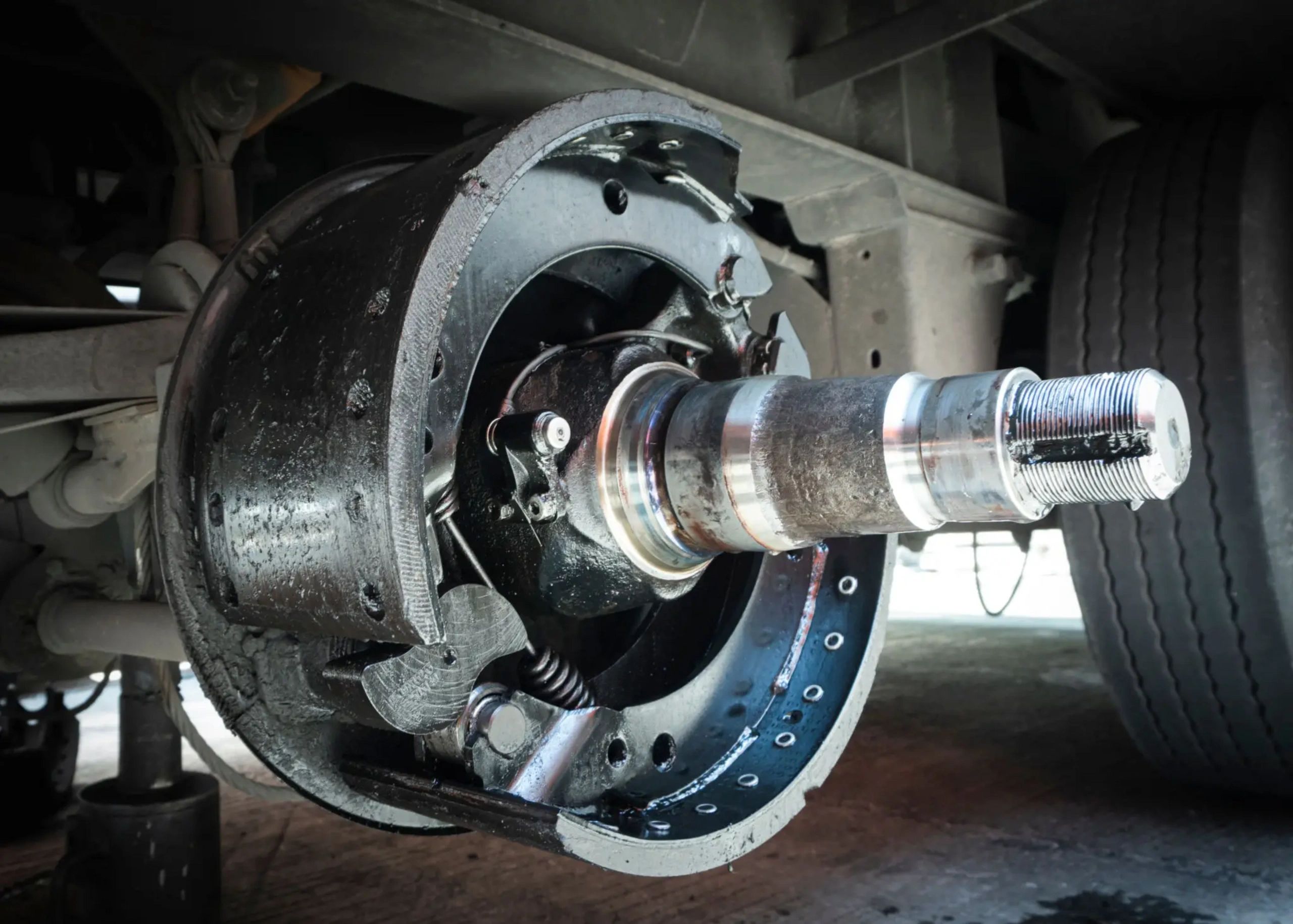 Close-up of a truck's exposed drum brake assembly without the wheel.