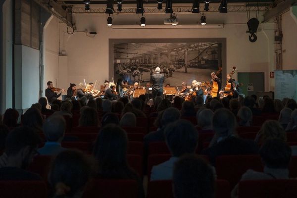 Orchestra performing for seated audience.