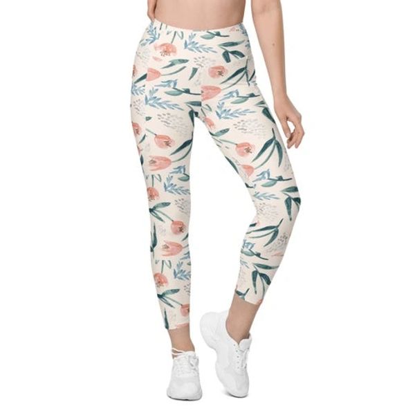Woman wearing floral patterned leggings with white sneakers.
