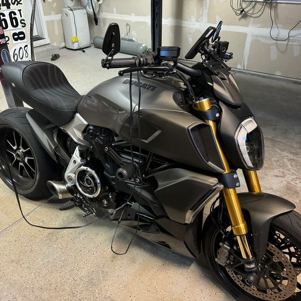 Matte black Ducati motorcycle in a garage.