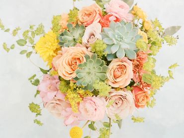 Vibrant bridal bouquet yellow, peach, orange tones, succulents at Nella Terra Cellars in Sunol, CA