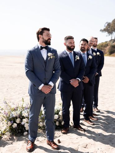 Groom and groomsmen standing with boutonnieres among florals at Seascape Beach Resort in Aptos, CA