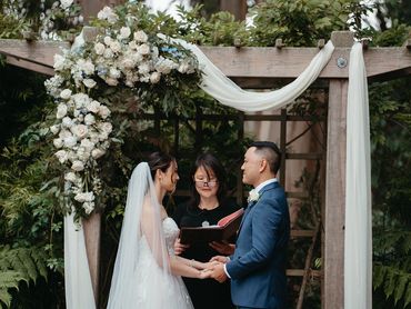 Bride and groom vow exchange under wooden arbor florals Wedgewood Golden Gate Club San Francisco, CA