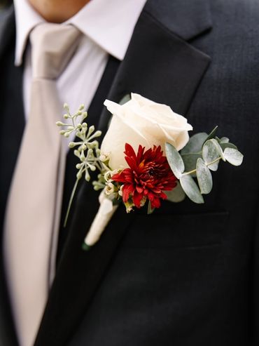The groom with a delicate burnt orange and white boutonniere at Nestldown in Los Gatos, CA