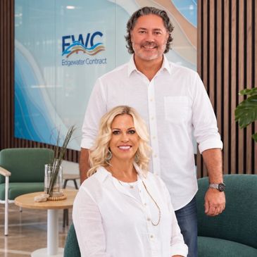 Two professionals posing in modern office space.