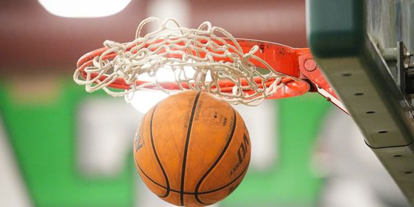 Basketball passing through the hoop during a game.