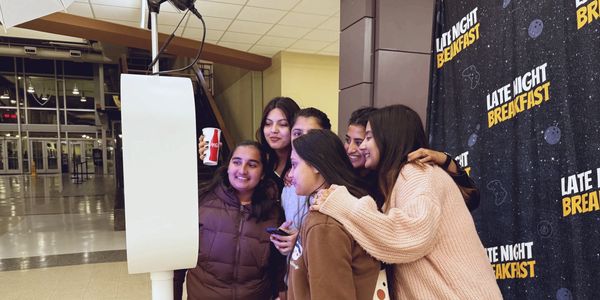 Group of girls smiling while looking at Photo Booth